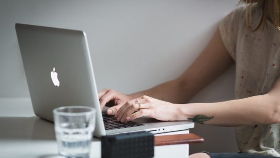 Woman working on laptop improving her writing skills